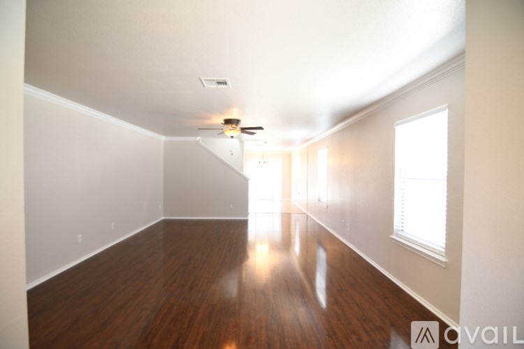 A spacious room with wooden floors and white walls.