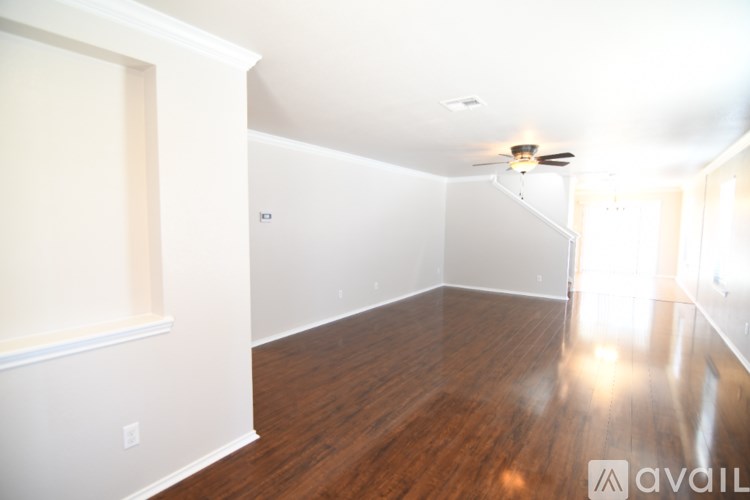 A room with wooden floors and a ceiling fan.