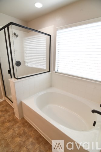 A bathroom with a tub and a shower stall.