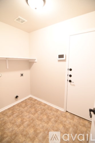 A room with a door and a shelf.