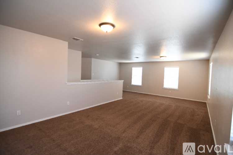 A large empty room with carpeted floor and white walls.