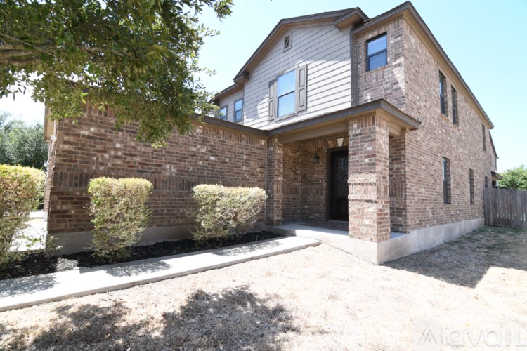 A house with a grey siding and a brick wall.