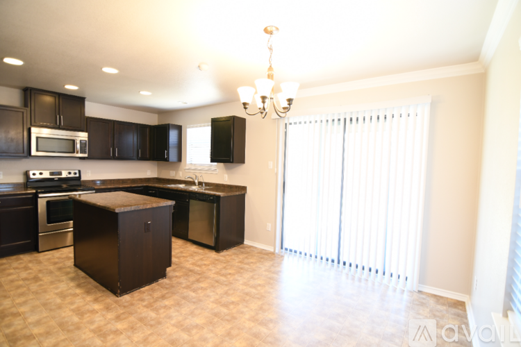 A kitchen with brown cabinets and a granite counter top.