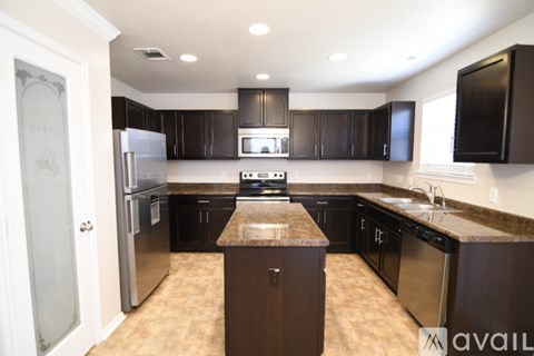 A kitchen with brown cabinets and a granite counter top.