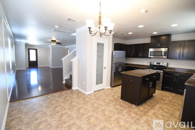 A kitchen with black cabinets and a white island.