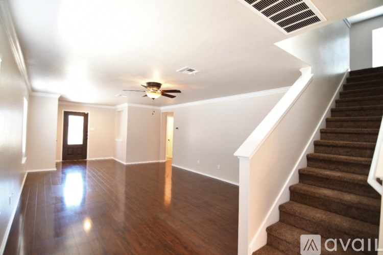 A spacious room with a staircase leading to the upper floor.