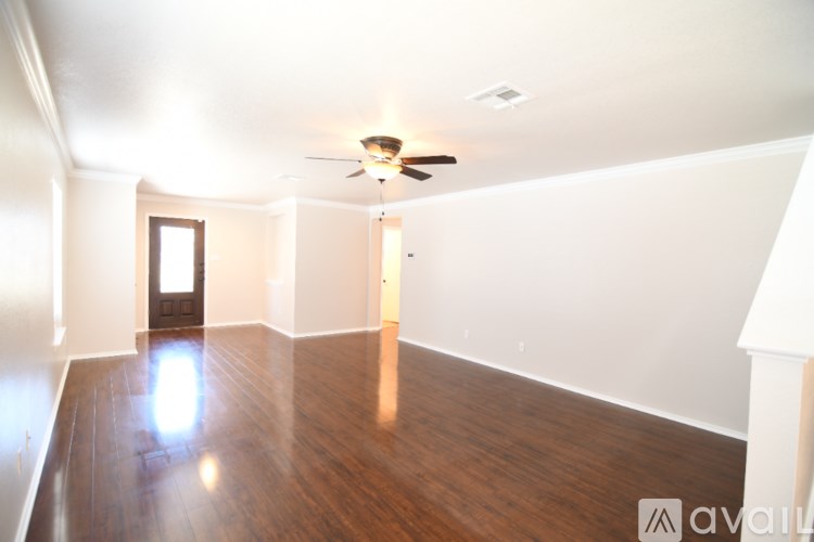 A room with wooden floors and a ceiling fan.