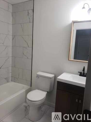 A bathroom with a toilet, sink, and tub.