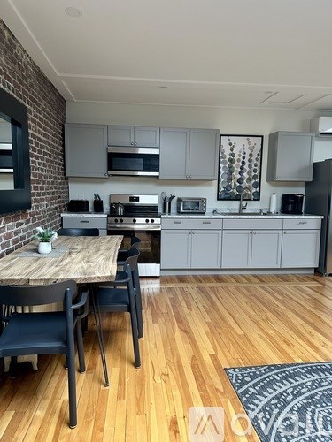 A kitchen with a table and chairs in front of a brick wall.
