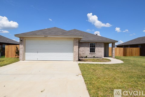 A house with a garage and a driveway in front of it.