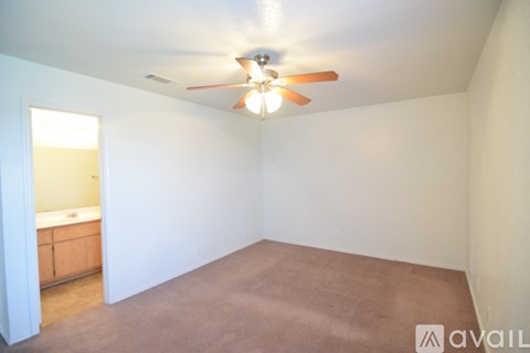 A room with a ceiling fan and a carpeted floor.
