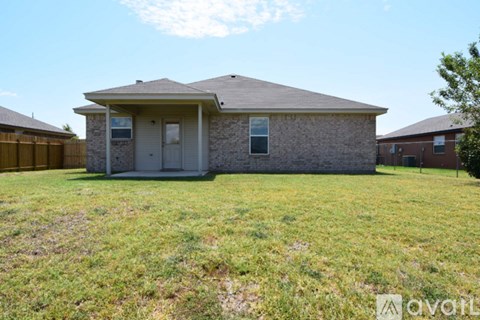 A house with a brown roof and a grey front yard.