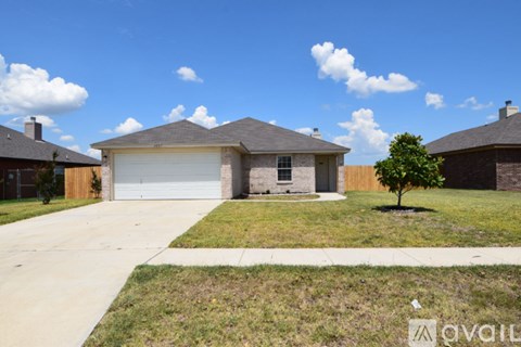 A house with a garage and a driveway in front of it.