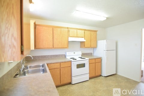 A kitchen with wooden cabinets and a white stove top oven.