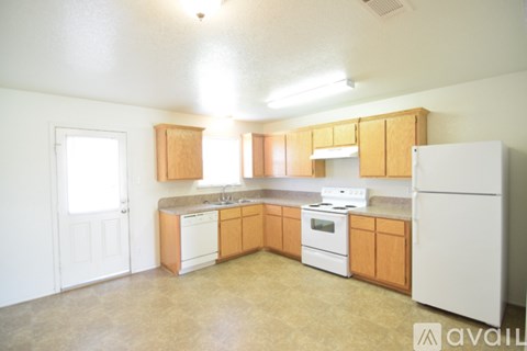 A kitchen with wooden cabinets and white appliances.