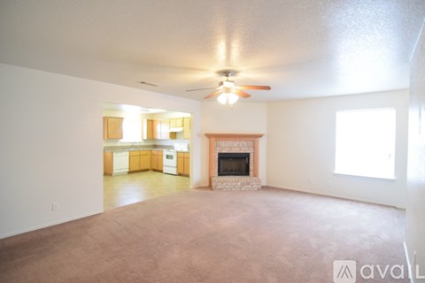 A living room with a fireplace and a ceiling fan.