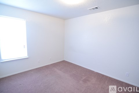 A room with a window and carpeted floor.