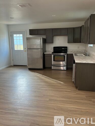A kitchen with a refrigerator, oven, and sink.