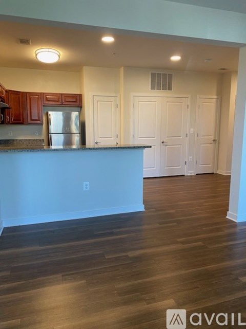 A kitchen with wooden cabinets and a stainless steel refrigerator.