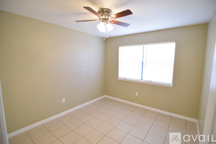 A room with a ceiling fan and a window.