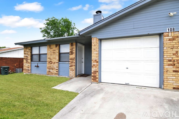 A house with the number 108 on it has a garage door and a chimney.