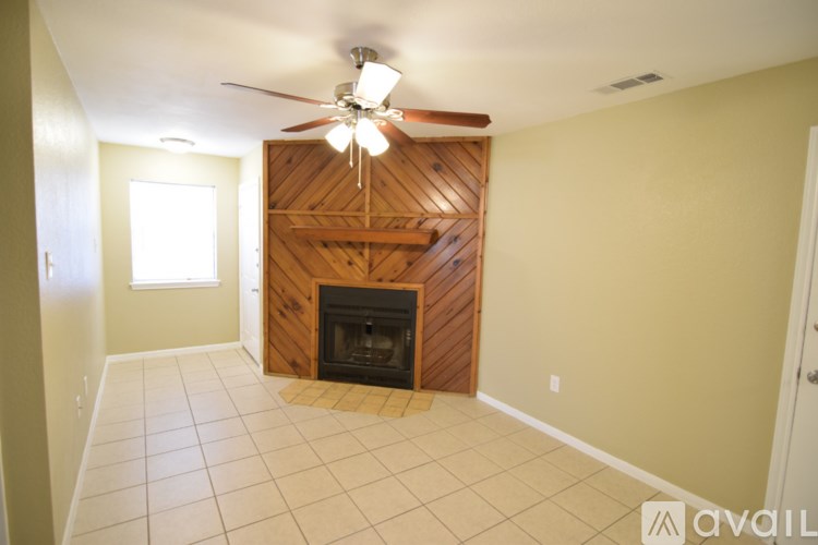 A room with a fireplace and a ceiling fan.