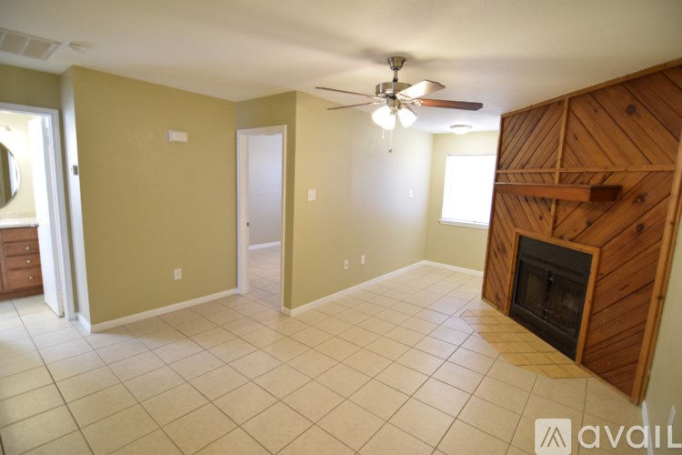 A room with a fireplace and a ceiling fan.