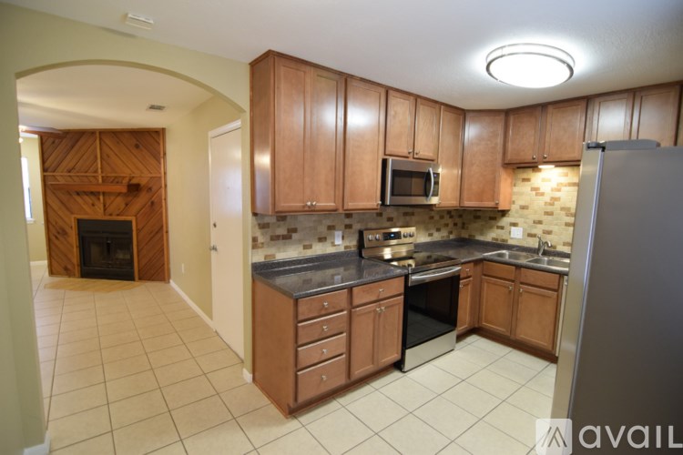 A kitchen with wooden cabinets and a tile floor.