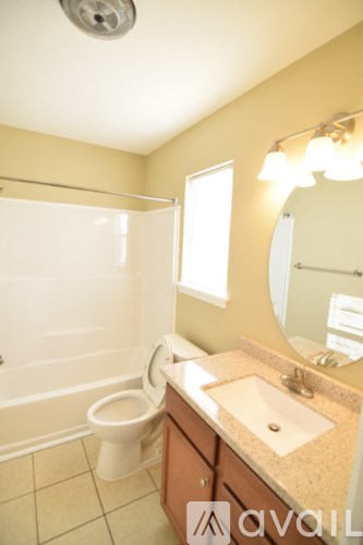 A bathroom with a toilet, sink, and mirror.
