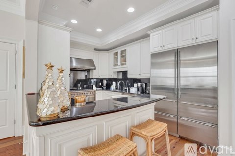 A kitchen with white cabinets and a dark countertop.