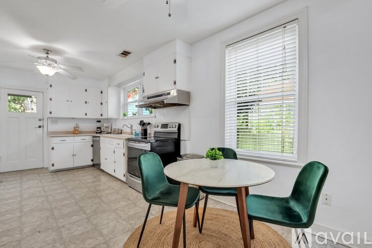 A kitchen with a table and chairs in front of a window.