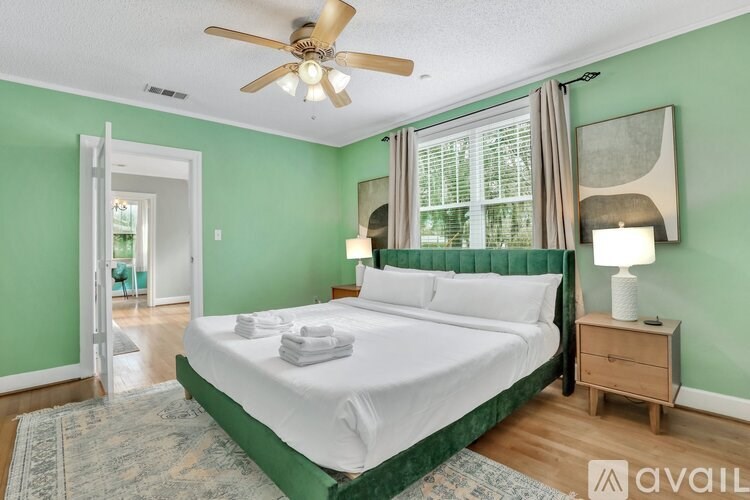 A bedroom with a bed, nightstand, and window.