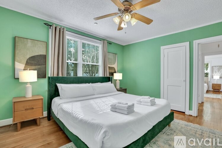 A bedroom with a bed, nightstand, and window.