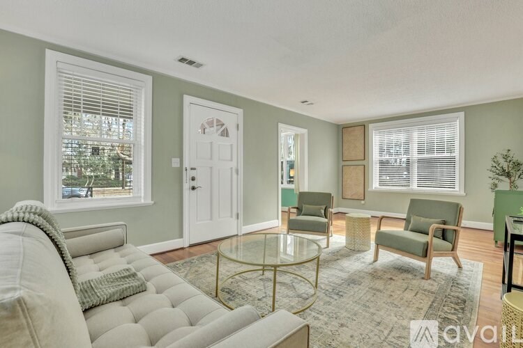A living room with a couch, chairs, and a coffee table.
