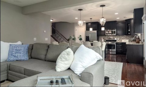 A modern living room with a grey couch and a coffee table in the foreground.