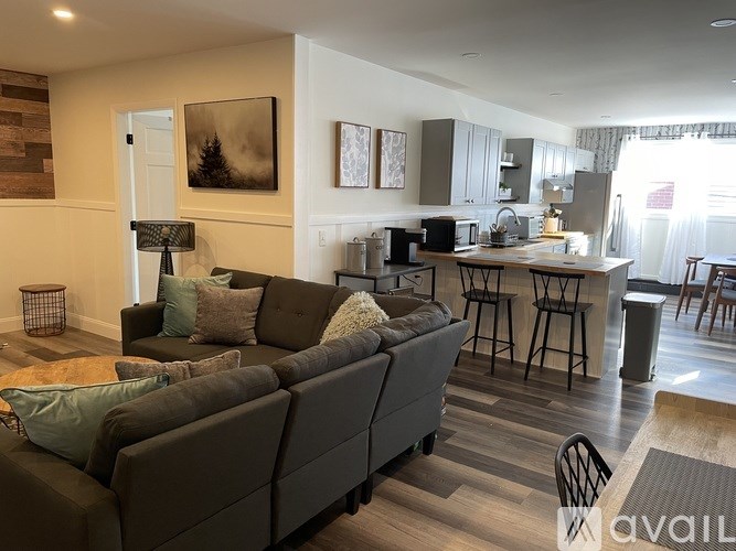 A living room with a grey couch and a wooden floor.