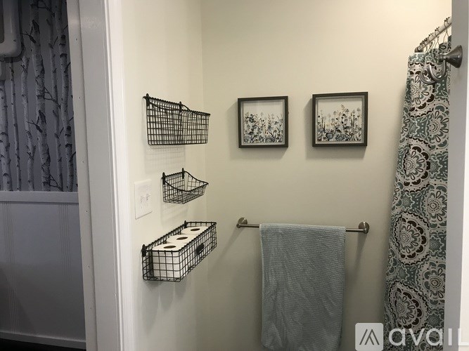 A bathroom with a towel rack and two pictures on the wall.
