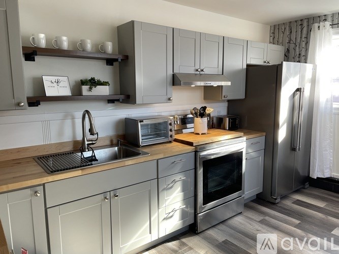A modern kitchen with stainless steel appliances and wooden countertops.