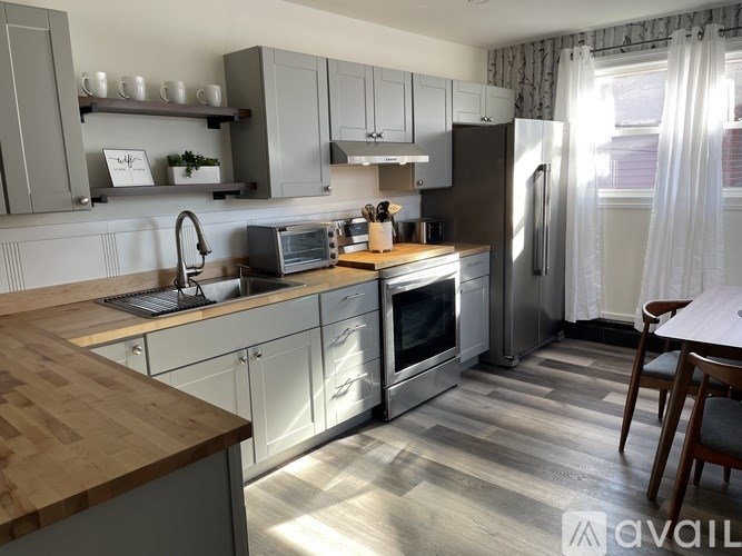A kitchen with a wooden counter top and stainless steel appliances.