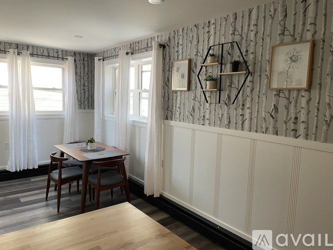 A dining room with a table set for two and a wallpapered wall.