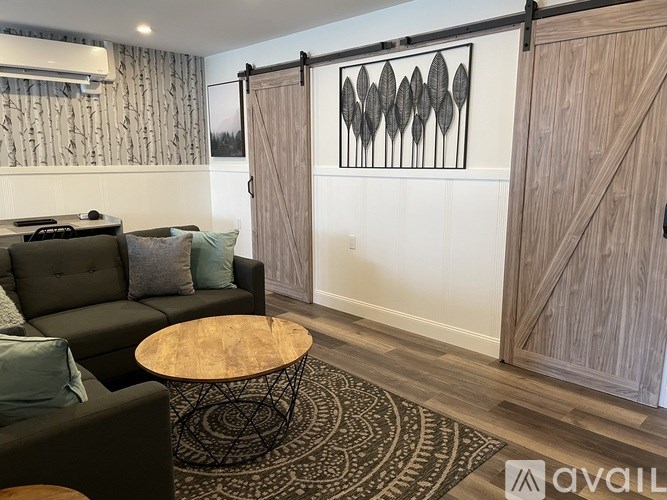 A living room with a couch, a coffee table, and a wall hanging.