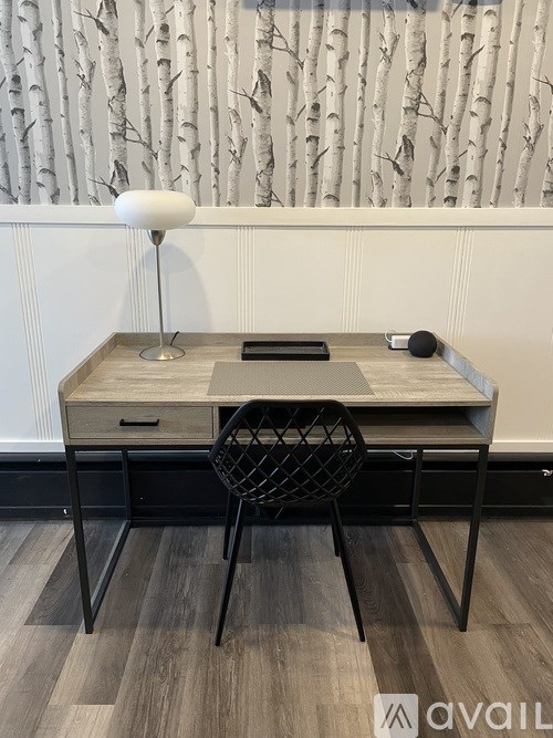 A desk with a chair and a lamp on it.