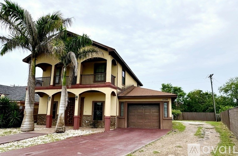 A house with a brown garage door and a red brick driveway.