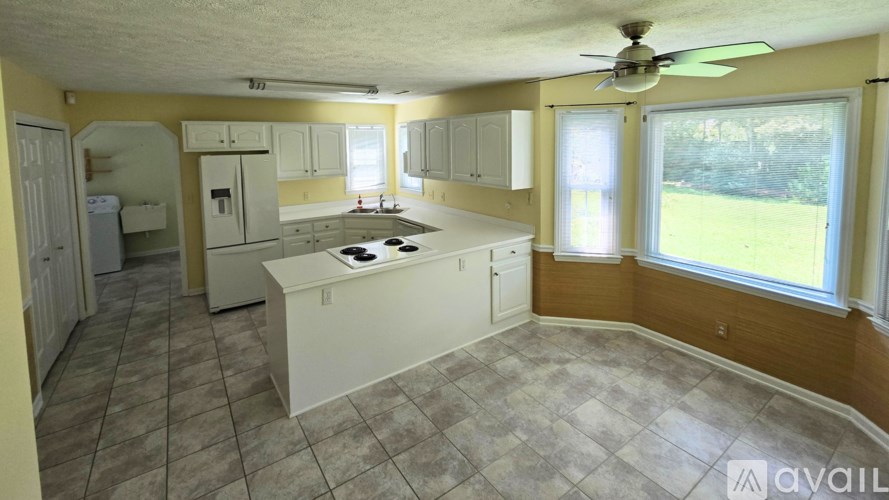 A kitchen with a white countertop and a fan on the ceiling.