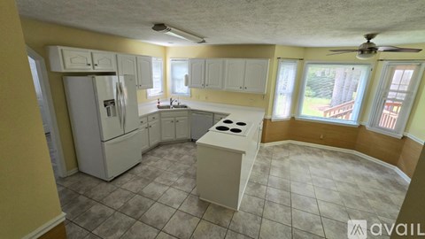 A kitchen with white appliances and cabinets is available for rent.