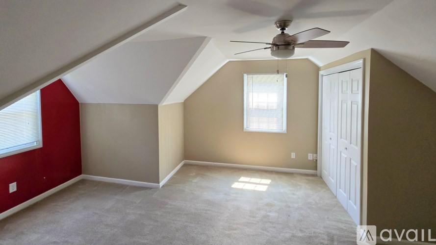 A room with a ceiling fan and a window.