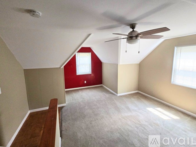 A room with a ceiling fan and a window.