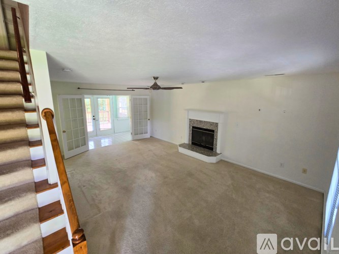 A living room with a fireplace and a ceiling fan.