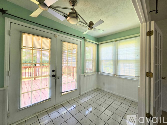 A room with a ceiling fan and tiled flooring.