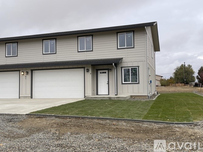 A two-story house with a garage and a driveway.